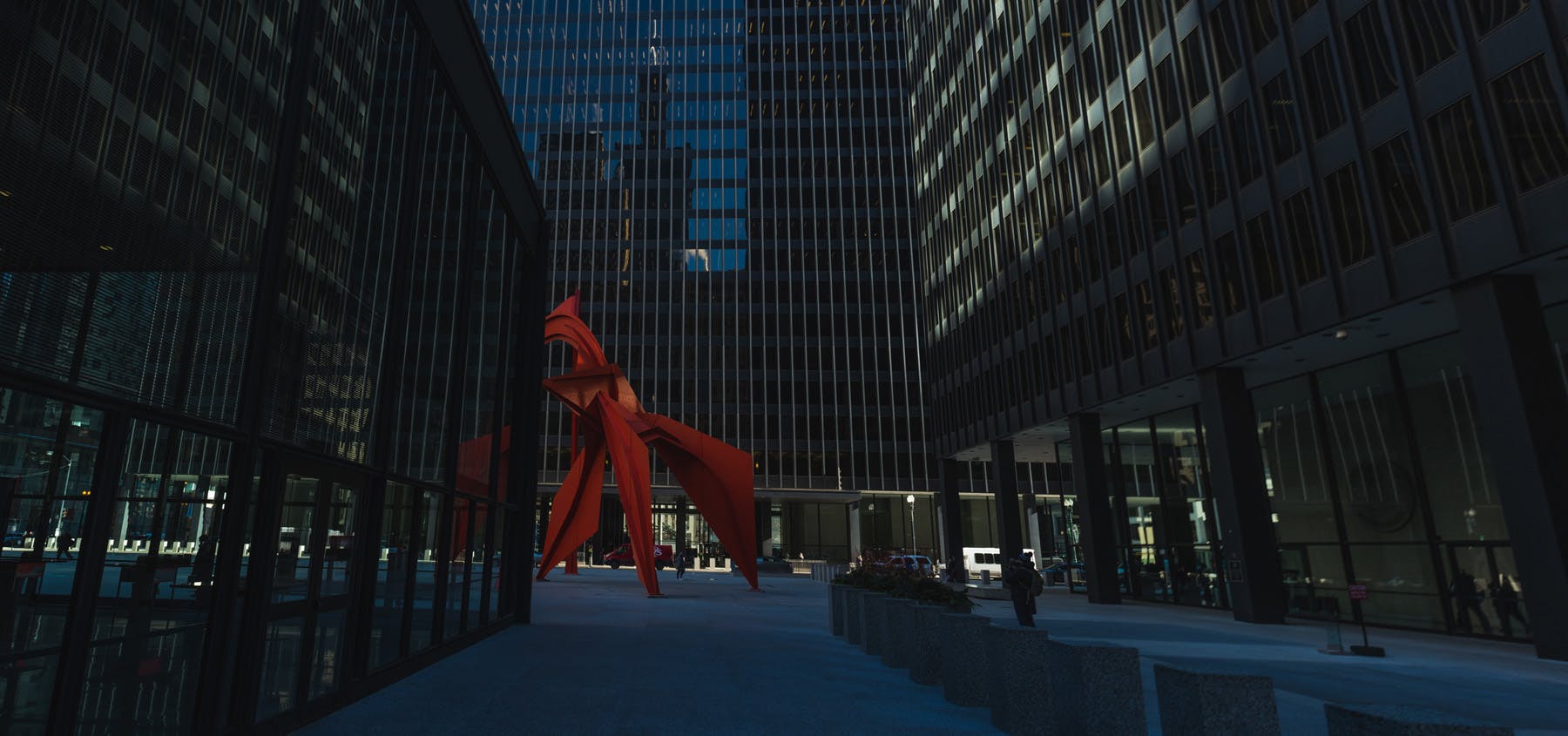 a picture of Calder's Flamingo slightly obscured by the US Post office building and you can see the Sears tower reflected on the building behind  the Flamingo.